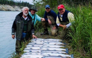 Guests and fishing guide posing with salmon