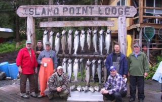 Guests and guides posing with over a dozen caught salmon