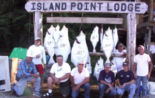 Guests and fishing guide posing with large halibut