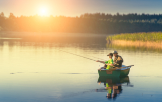 Man and boy fishing from a boat at sunrise