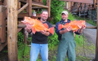 Guide and guest holding large rock fish