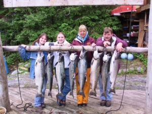 A group of avid anglers proudly display their Alaskan salmon bounty.