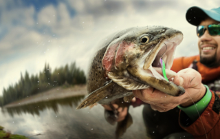 Man holding a rainbow trout with face close up