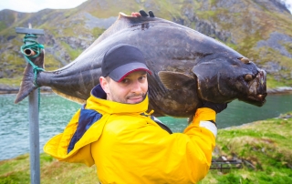 An avid angler hauls a large halibut that was caught during fall fishing season.