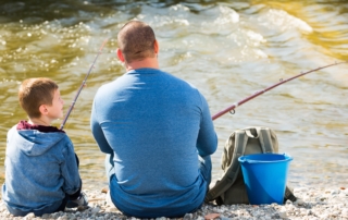 A man fishing with his son in Alaska.