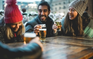 Two women and one man drinking the best beer in Alaska at a bar.