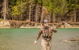 A man on in the river following a Alaska Helicopter tour for Fly Fishing.